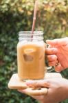 Hand On Glass Of Iced Milk Coffee With Vintage Filter Effect Stock Photo