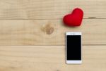 Red Heart And Smartphone On Wood Background Stock Photo