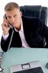 Ceo Talking Over Phone With Laptop Stock Photo