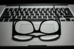 Vintage Eye Glasses On Laptop Trackpad Low Key Light Stock Photo