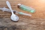 Syringe And Drug And Spoon Cooked Heroin On A Wooden Background Stock Photo