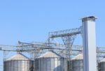 Exterior Structure Of New Agriculture Silo Building Against Blue Stock Photo