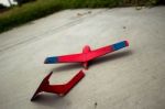 Wooden Painted Glider Lying Broken On A Sidewalk Stock Photo