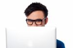 Mischievous Boy Hiding His Face With Laptop Stock Photo