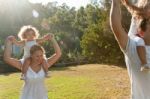 Parents Giving A Shoulder Ride To Kids Stock Photo