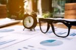 Glasses And Clock On The Business Paper. Report Chart Stock Photo