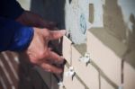 Worker Puts The Ceramic Tiles On The Wall Stock Photo