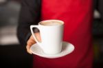 Hands Of Waiter Serving A Cup Of Cappucino Stock Photo