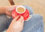 Woman In Torn Jeans Sitting At Coffee Shop Stock Photo