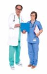 Doctors Analyzing Report Together Stock Photo