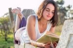 Girl Reading Book Outdoors Stock Photo