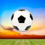 Hand Holding Soccer Ball With Soccer Field And Sunset Sky Stock Photo