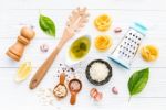 The Ingredients For Homemade Pesto Pasta On White Wooden Backgro Stock Photo