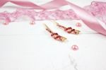 Golden Hairpins With Pink Gemstone And Pink Ribbon On Pink Background Stock Photo