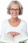 Smiling Senior Woman Reading A Book Stock Photo