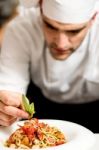 Chef Garnishing Pasta Stock Photo