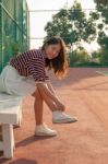 Portrait Of Beautiful Sport Girl Sitting In Tennis Courts Looking To Camera With Smiling Face Use For People And Healthy Lifestyle Activities Stock Photo