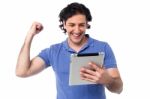 Excited Young Man Holding Touch Pad Device Stock Photo