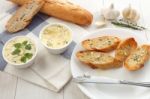 Baguette With Herb Butter And Rosemary Thyme On Rustic Wooden Background Stock Photo