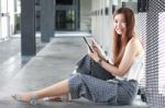 Portrait Of Thai Adult Beautiful Girl Using Her Tablet And Smile In University Stock Photo