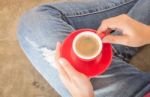 Woman In Torn Jeans Sitting At Coffee Shop Stock Photo