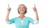 Beautiful Senior Lady Pointing Upwards Stock Photo