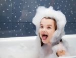 Surprised Little Girl Sitting In A Bath Stock Photo