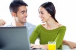 Happy Young Couple Browsing Internet At Home Stock Photo