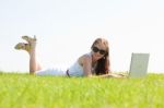 Oung Female Lying On The Grass In The Park Using A Laptop Stock Photo