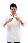 Portrait Of Young Male Chef Holding Fork And Knife Stock Photo