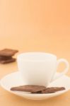 White Mug Of Hot Coffee And Chocolate Pieces Stock Photo