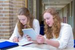 Two Teenage Girls Studying In Corridor Of School Stock Photo