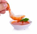 Hand Holds Shrimp With Chili Sauce Isolated On White Background Stock Photo