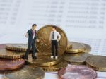 Miniature Businessman Stand On Euro Coins And Book Bank. Busines Stock Photo