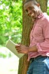 Relaxed Smiling Man Using His Digital Tablet Stock Photo