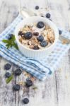 Bowl Of Muesli With Fresh Blueberries On White Wooden Table Stock Photo