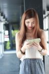 Portrait Of Thai Adult Beautiful Girl Using Her Smart Phone And Smile Stock Photo