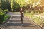 Women Runners Sprinting Outdoors. Sportive People In Public Park Stock Photo