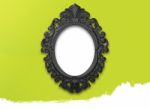 Oval Black Picture Frame With A Decorative On Green Wall Stock Photo