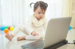 Little Asian Girl Play Laptop In Home Stock Photo