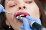 Dentist Curing A Female Patient Stock Photo