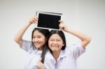 Two Asia Thai High School Student Uniform Best Friends Beautiful Girl Using Her Tablet And Funny Stock Photo