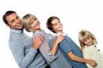 Cheerful Family Of Four Leaning Backwards Stock Photo