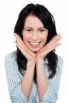 Smiling Young Woman Resting Her Chin Over Palms Stock Photo