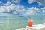 Red Cocktail On White Table Set Over Ocean Stock Photo