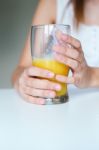 Smiling Woman Drinking Orange Juice At Home Stock Photo