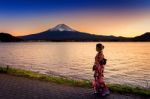 Asian Woman Wearing Japanese Traditional Kimono At Fuji Mountain. Sunset At Kawaguchiko Lake In Japan Stock Photo