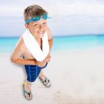 Smiling Boy Standing On Beach Background Stock Photo