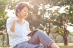 Woman Using Digital Tablet In Park Stock Photo