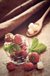 Red Strawberries In Glass Jar On Sackcloth Stock Photo